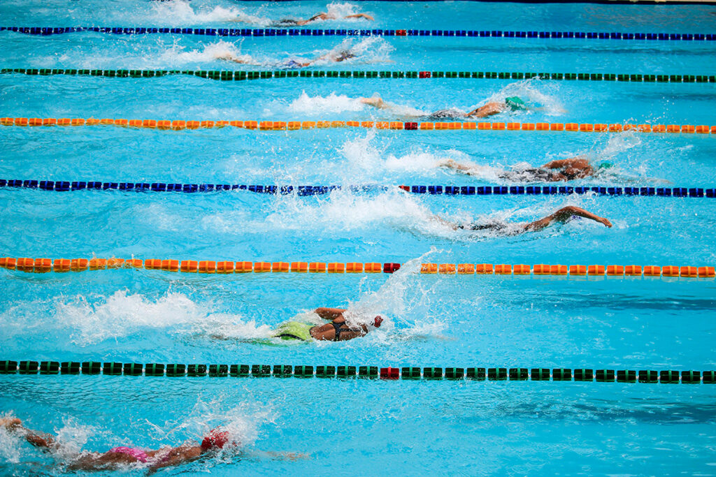 Swimmers swimming in swim lanes